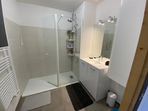 une salle de bain blanche avec une douche et un lavabo dans l'établissement Charmant appart 2 ch + coin nuit, balcon sud, garage, près de La Clusaz et commerces, St Jean de Sixt - FR-1-459-195, à Saint-Jean-de-Sixt