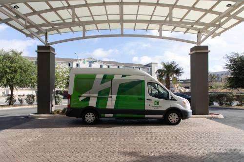 a green and white van parked under a building at Holiday Inn Hotel & Suites Northwest San Antonio by IHG in San Antonio