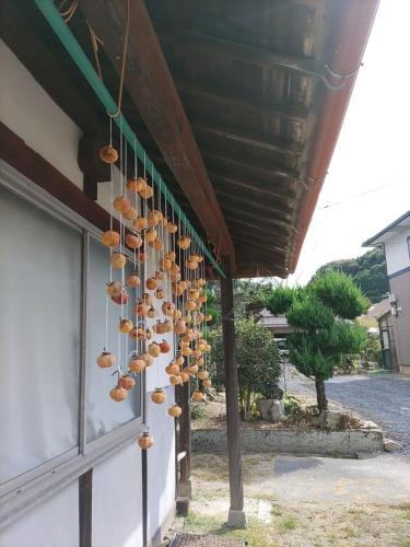 Um monte de chapéus pendurados num edifício. em もりのもむ Morinomomu Guest House in Mitsuo 