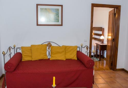 a red couch with yellow pillows in a living room at Casa Da Eira Longa in Vilar