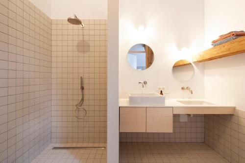 ein Bad mit einer Dusche und einem Waschbecken in der Unterkunft Origineel gerenoveerde schuur nabij Antwerpen in Zoersel