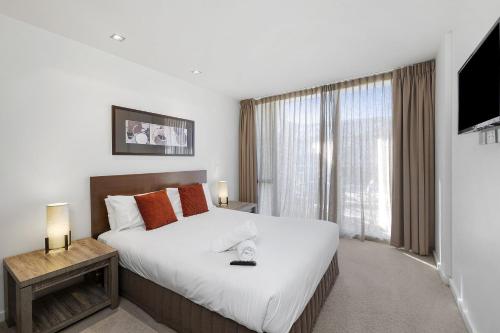 a bedroom with a large bed and a large window at Resort Apartment 224 in Torquay