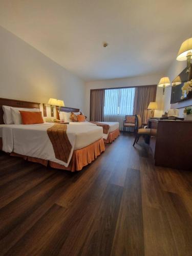 a hotel room with two beds and a desk at Ramada by Wyndham D MA Bangkok in Bangkok