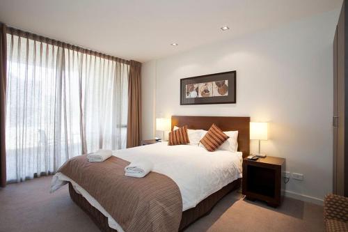 a bedroom with a large bed and a large window at Resort Apartment 263 in Torquay