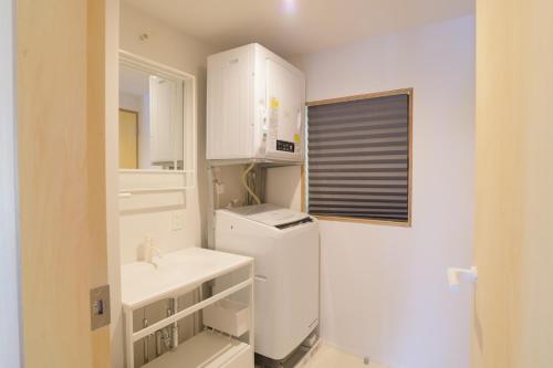 a white kitchen with a sink and a refrigerator at SEN.RETREAT TAKAHARA in Tanabe