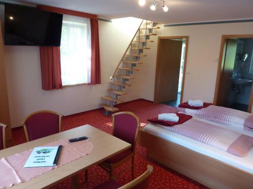 a room with a bed and a table and a ladder at Spreewald Pension Spreeaue in Burg