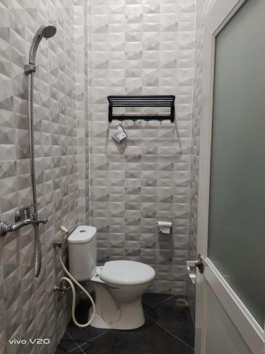 a small bathroom with a toilet and a shower at Bu Sepuh GuestHouse in Sangkanurip