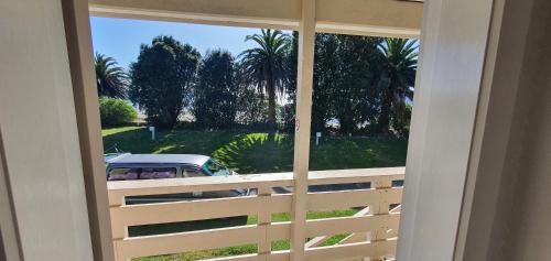 a window with a view of a car parked outside at Golden Bay Holiday Park in Onekaka