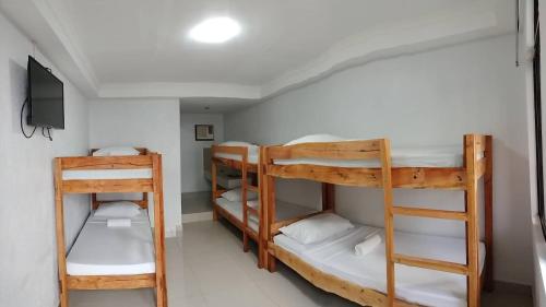 長灘島的住宿－蘿拉小屋酒店，客房设有三张双层床和电视。