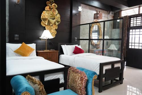 Habitación con 2 camas y una silla. en Vathanagul Resort en Chiang Rai