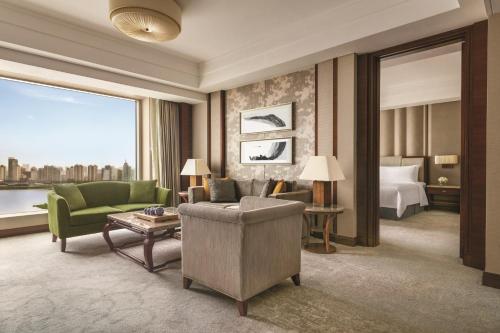 a hotel room with a couch and a bed at Shangri-La Nanchang丨Adjacent to Pavilion Prince Teng Prime river view in Nanchang