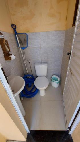 Un baño pequeño con inodoro y lavabo. en Casa Centro com Piscina, en Ubatuba