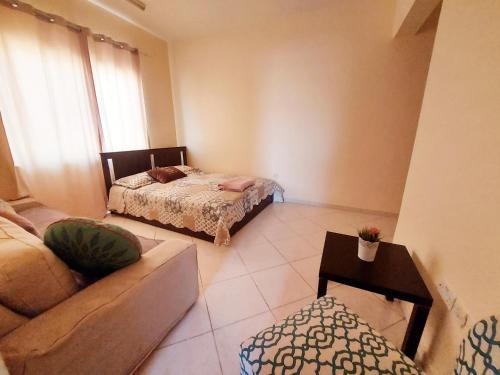 a living room with two beds and a couch at DO ALL BY WALKING DISTANCE IN ALAIN in Al Ain