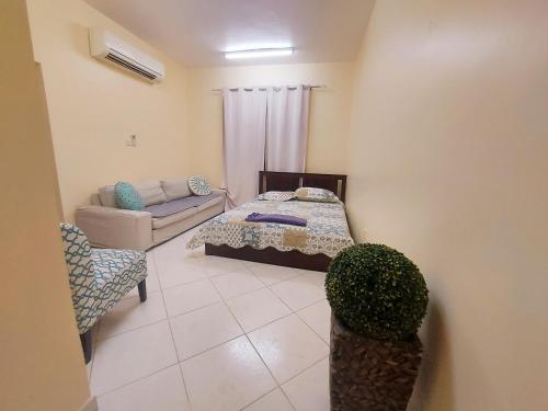 a living room with a bed and a couch at DO ALL BY WALKING DISTANCE IN ALAIN in Al Ain