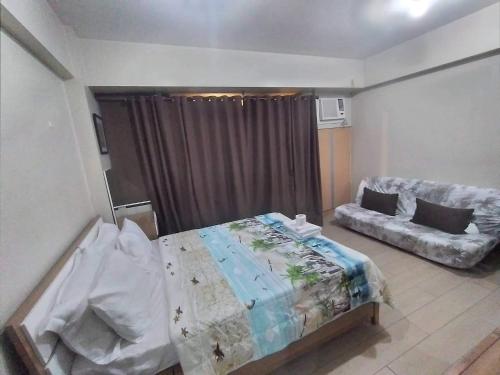 - une chambre avec un lit et un canapé dans l'établissement RQUI CONDOTEL NEWPORT PASAY, à Manille