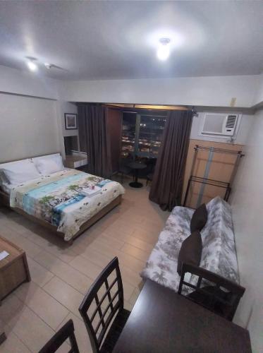 a bedroom with a bed and a couch and a desk at RQUI CONDOTEL NEWPORT PASAY in Manila