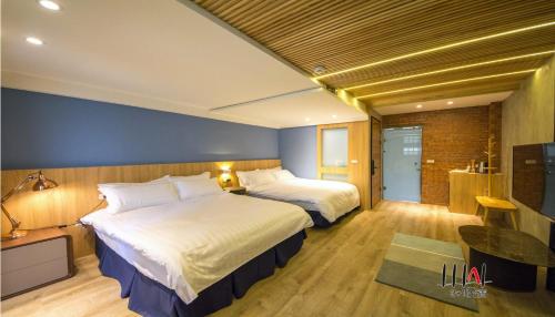 a hotel room with two beds and a television at Three Adds One Homestay in Luodong