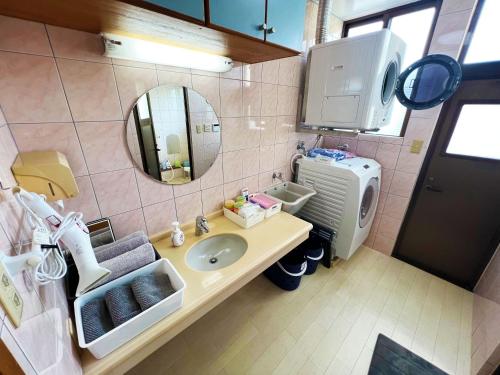 a bathroom with a sink and a mirror at やんばる別荘三原でーじまぎー -Yanbaru stay MIHARA VILLA GRANDE- in Nago