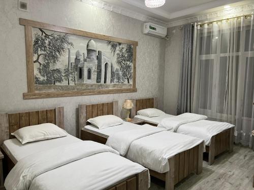 3 Betten in einem Zimmer mit Wandgemälde in der Unterkunft Ideal Hotel in Samarkand