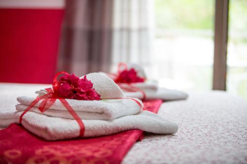 a pile of towels with a red flower on a table at B&B Pepito in Cefalù