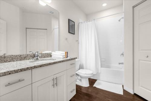 uma casa de banho branca com um lavatório e um WC em 4 Bedrooms 3 Bathrooms Lucaya Village 21-101 em Orlando