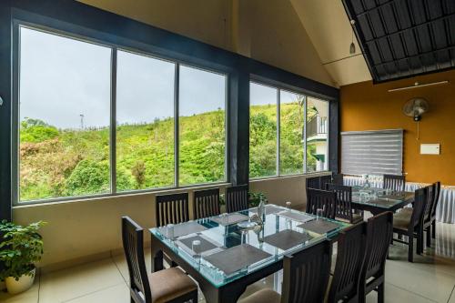 Un comedor con mesa y sillas y ventanas. en Pine Clough Resort Vagamon, en Vagamon