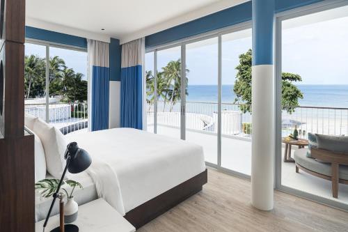Avani Chaweng Samui Hotel & Beach Club في شاطئ تشاوينغ: غرفة نوم مع سرير وشرفه مع المحيط