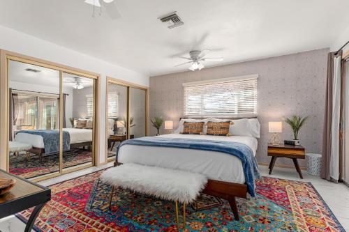 a bedroom with a large bed and a living room at Tortoise Oasis - Hot tub, Shuffleboard, & More! in Yucca Valley