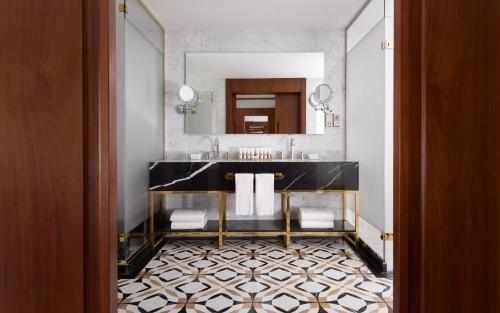 a bathroom with a black sink and a mirror at Swissôtel Wellness Resort Alatau Almaty in Almaty