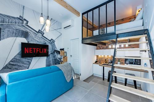 sala de estar con sofá azul y escalera en L'Industriel - Appart'Hôtel SPA - Clim - Melina & Alfred Agen, en Agen