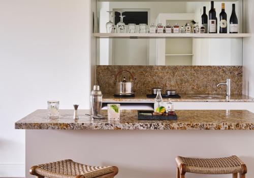 a kitchen with a counter with two stools at Lancemore Milawa in Milawa