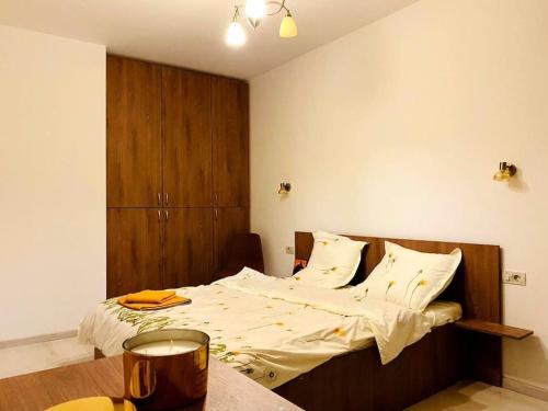 Luxury apartment في أراد: غرفة نوم مع سرير مع اللوح الأمامي الخشبي