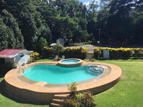 uma piscina num quintal com paisagismo em Camguin Lanzones Resort em Balbagon