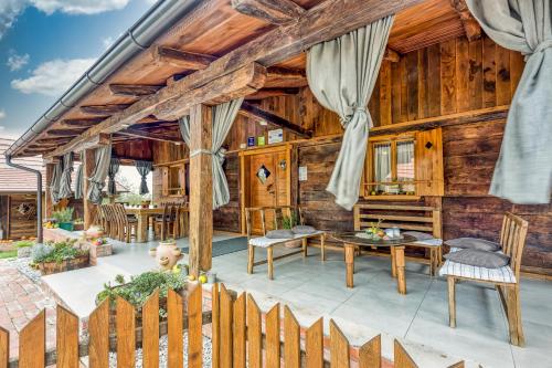 a house with wooden walls and a fence at Sustainable Wellness House Lina - Happy Rentals in Lopatinec