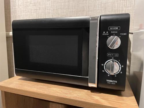 a microwave oven sitting on top of a wooden shelf at Hotel Route-Inn Saku Minami Inter in Saku