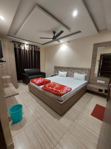 a bedroom with a bed and a chair in it at HOTEL SATYAM PALACE in Deoghar