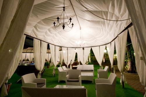 a tent with white chairs and tables and a chandelier at Villaggio La Pescaccia in San Clemente