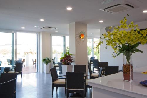 a restaurant with chairs and tables and a vase of flowers at Villaggio La Pescaccia in San Clemente
