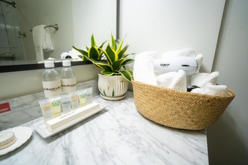 a bathroom counter with a basket of towels and a mirror at Paradiso Resort & Spa in Saipan