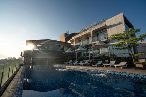 a hotel with a swimming pool in front of a building at Grandia Hotel in Bandung