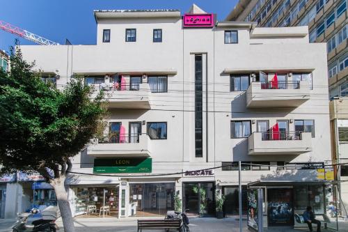 un edificio blanco alto con un letrero. en Silicate Ben Yehuda - Smart Hotel by Loginn Tel Aviv, en Tel Aviv