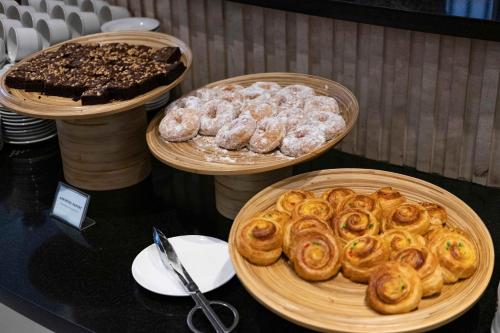 three baskets filled with different types of pastries on a table at Grandia Hotel in Bandung