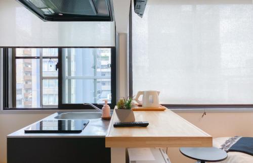 a kitchen with a table and a sink and two windows at KEYHOTEL-5minutes for walk to Akihabara Electric Town in Tokyo