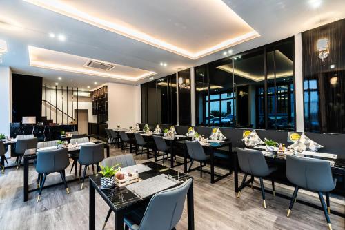 een restaurant met tafels, stoelen en ramen bij One Patio Hotel Pattaya - SHA Extra Plus in Pattaya