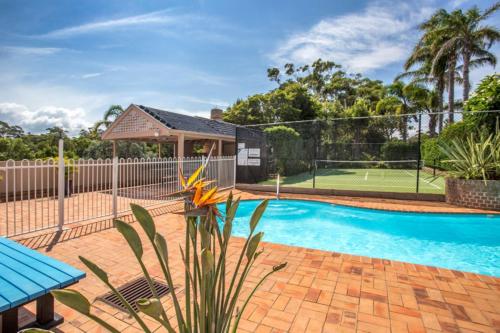 a house with a tennis court and a pool at The Sands in Mollymook