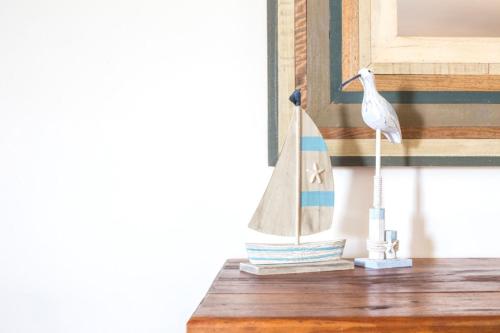 a small white bird sitting on a wooden table at Summer Days in Mollymook