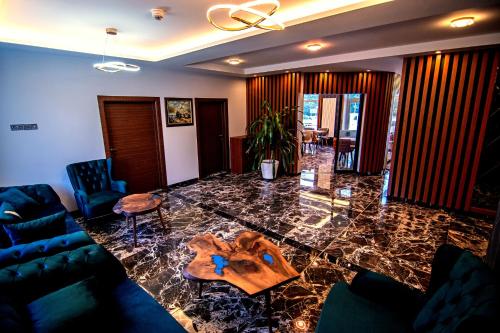 a living room with a glass table with a blue couch at Hotel Yaman in Eberswalde