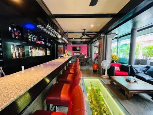 a bar with red chairs and a bar counter at Baipho Lifestyle in Patong Beach