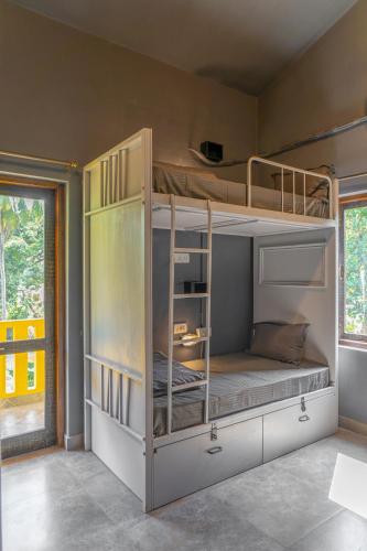 a bedroom with two bunk beds in a room at Whoopers Boutique Hotel, Anjuna in Anjuna