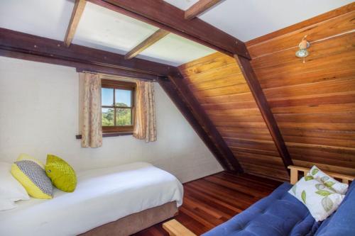 ein kleines Zimmer mit einem Bett und einem Sofa in der Unterkunft Stone Cottage in Milton